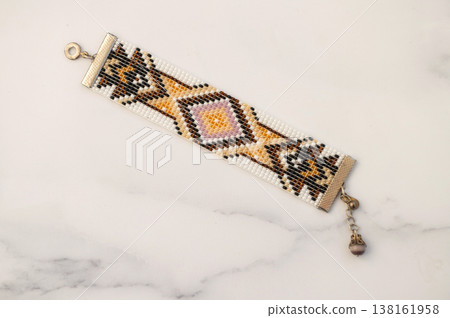 Handcrafted geometric beaded bracelet on marble background Handcrafted geometric beaded bracelet on marble background 138161958