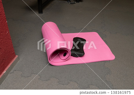 Pink yoga mat with knee pad on gym floor for exercise and stretching Pink yoga mat with knee pad on gym floor for exercise and stretching 138161975