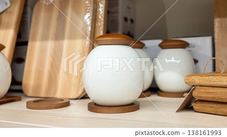 Decorative ceramic spice jars with wooden lids on kitchen shelf 138161993