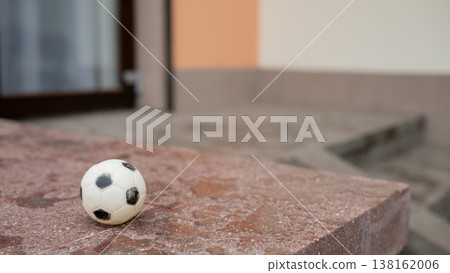 Small soccer ball on stone step in urban setting Small soccer ball on stone step in urban setting 138162006