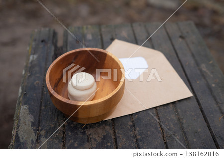 Wooden bowl with soap figurine and envelope on rustic surface Wooden bowl with soap figurine and envelope on rustic surface 138162016