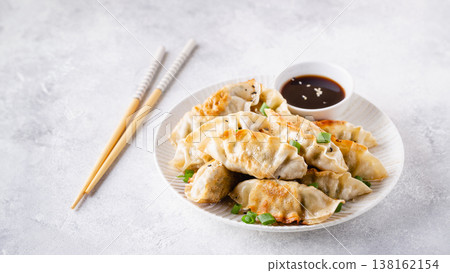 Fried dumplings gyoza with soy sauce, and chopsticks. 138162154