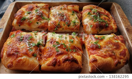 Baked cheesy bread squares on tray with herb garnish for recipe banner menu presentation and family serving inspiration Baked cheesy bread squares on tray with herb garnish for recipe banner menu presentation and family serving inspiration 138162295