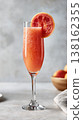 Flute glass with grapefruit juice garnished with slice 138162355