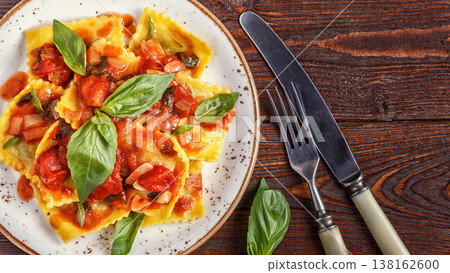 Ravioli with tomato sauce and basil on dark background. Ravioli with tomato sauce and basil on dark background. 138162600
