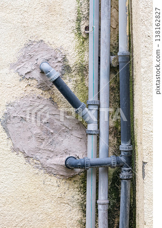 Old water supply pipes with valves and meters mounted on exterior wall of residential building. Urban infrastructure and water distribution system concept 138162827