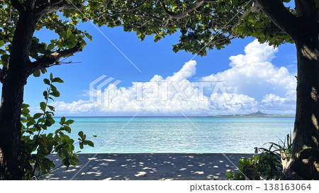 The Bise Fukugi tree-lined street, the expansive emerald sea, and Ie Island: A natural frame in Motobu Town, Okinawa. The Bise Fukugi tree-lined street, the expansive emerald sea, and Ie Island: A natural frame in Motobu Town, Okinawa. 138163064