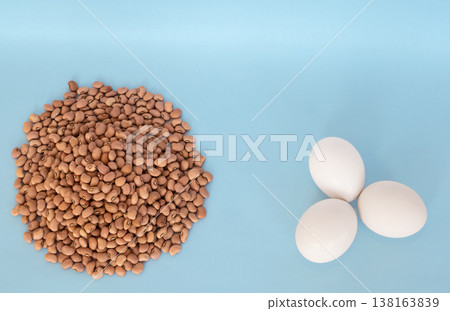Red cowpeas and organic white chicken eggs on the blue background 138163839