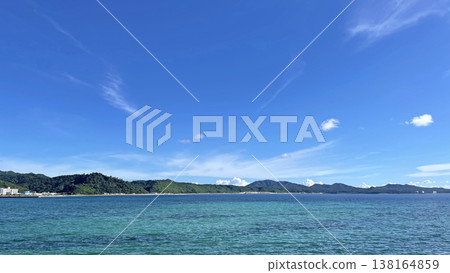A summer coastal scene with a blue sky and emerald green sea. A summer coastal scene with a blue sky and emerald green sea. 138164859