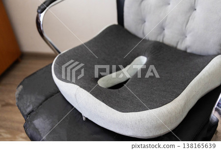 Ergonomic cushion on office chair providing posture support and comfort for extended sitting periods, design of product emphasizes health of spine 138165639