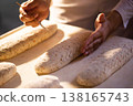 Baker hands scoring raw bread dough with fork tool, preparation of artisanal bakery product before baking, traditional manual bread making process 138165743