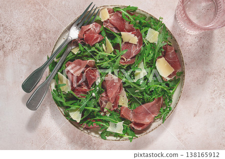 Fresh arugula salad with prosciutto and grated parmesan cheese, on a plate, homemade, no people, Fresh arugula salad with prosciutto and grated parmesan cheese, on a plate, homemade, no people, 138165912
