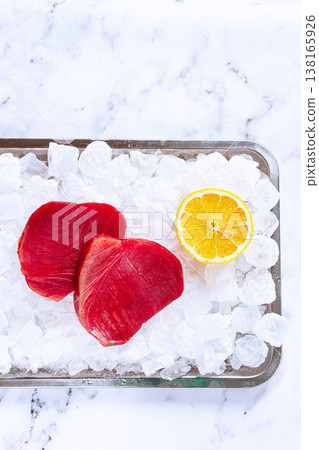 Fresh tuna and lemon, on ice ready, for preparation, at a seafood market Fresh tuna and lemon, on ice ready, for preparation, at a seafood market 138165926