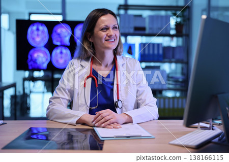 Smiling doctor reviews patient data in a modern medical office during a late afternoon consultation Smiling doctor reviews patient data in a modern medical office during a late afternoon consultation 138166115