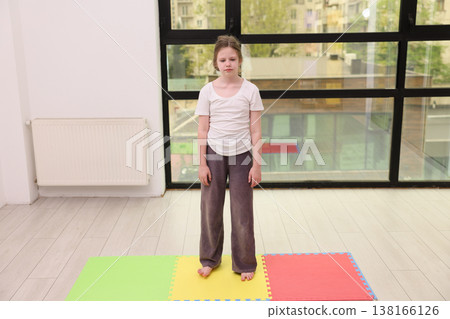 Young girl practices focus and balance in a bright studio filled with natural light during a calm morning session 138166126