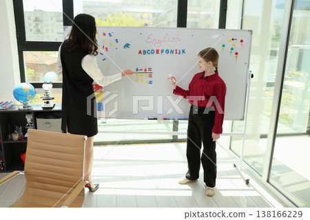 Creative English lesson with a teacher and student in a bright classroom setting, showcasing enthusiastic learning and collaboration Creative English lesson with a teacher and student in a bright classroom setting, showcasing enthusiastic learning and collaboration 138166229