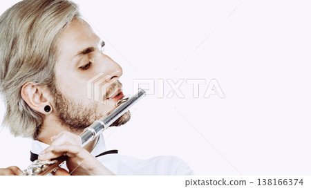 Male flutist playing his flute closeup 138166374