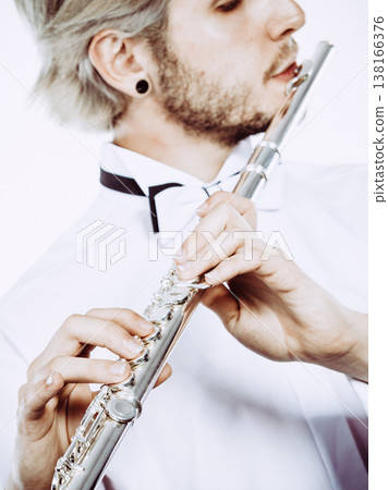 Male flutist playing his flute closeup Male flutist playing his flute closeup 138166376