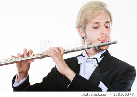 Male flutist wearing tailcoat plays flute Male flutist wearing tailcoat plays flute 138166377