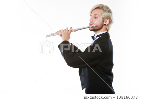 Male flutist wearing tailcoat plays flute Male flutist wearing tailcoat plays flute 138166378