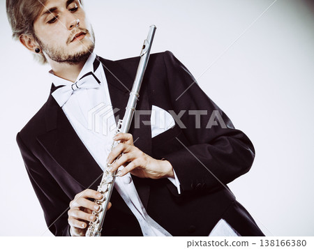 Male flutist wearing tailcoat holds flute Male flutist wearing tailcoat holds flute 138166380