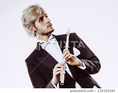 Male flutist wearing tailcoat holds flute 138166384