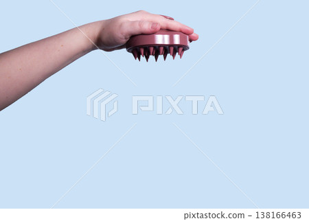 Hair pink scalp massager in woman hand on the pink background isolated. Image with copy space. Mock up for design and banner Hair pink scalp massager in woman hand on the pink background isolated. Image with copy space. Mock up for design and banner 138166463