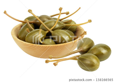 Capers in wooden bowl isolated on white background. Pickled or canned capers. Capers in wooden bowl isolated on white background. Pickled or canned capers. 138166565