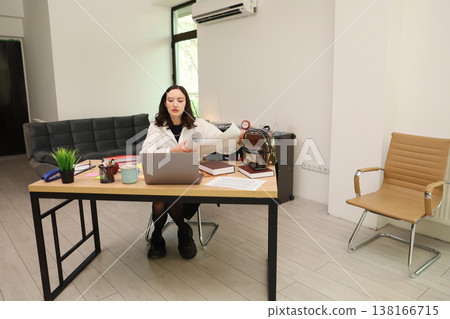 Young professional engaged in remote work at a modern office setting with clean lines and minimalistic decor Young professional engaged in remote work at a modern office setting with clean lines and minimalistic decor 138166715