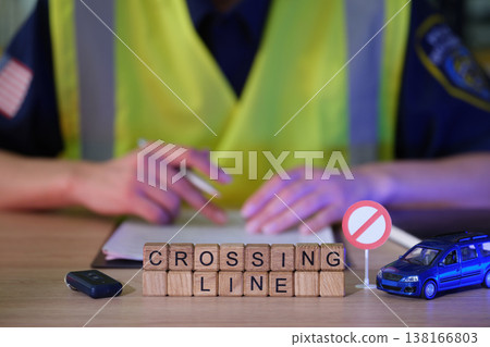 Traffic officer reviews rules at a safety checkpoint with toys and signs highlighting safety concerns in the community Traffic officer reviews rules at a safety checkpoint with toys and signs highlighting safety concerns in the community 138166803