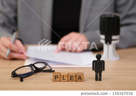 Legal proceedings unfold with a plea statement on the table during an important court session in an attorney's office Legal proceedings unfold with a plea statement on the table during an important court session in an attorney's office 138167038