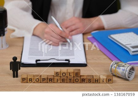 Exploring the concept of sole proprietorship through writing, planning, and financial planning at a cluttered workspace Exploring the concept of sole proprietorship through writing, planning, and financial planning at a cluttered workspace 138167059