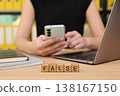 Working in a modern office while questioning the truth behind information on a smartphone 138167150