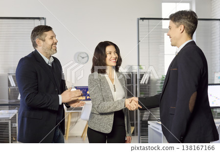 Smiling business partners shake hands in office, celebrating deal and teamwork Smiling business partners shake hands in office, celebrating deal and teamwork 138167166