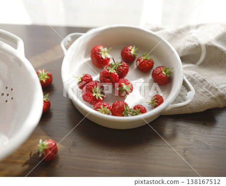 Fresh red strawberries in white ceramic vintage bowl on dark wooden table. Aesthetic food photography showcases organic summer berries for slow living breakfast and cottagecore kitchen vibes. Fresh red strawberries in white ceramic vintage bowl on dark wooden table. Aesthetic food photography showcases organic summer berries for slow living breakfast and cottagecore kitchen vibes. 138167512