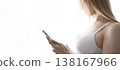 A blonde-haired girl looks thoughtfully at her phone. 138167966