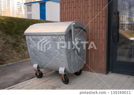 Metal garbage container near building waste management concept Metal garbage container near building waste management concept 138168011
