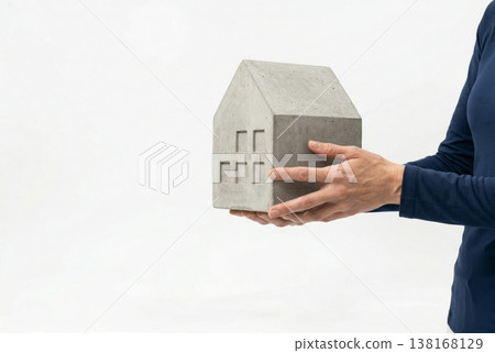 Hands Holding Concrete House Model on White Background 138168129
