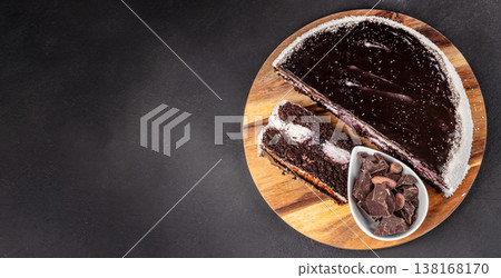 Chocolate cake with slice and dark chocolate on wooden board top view Chocolate cake with slice and dark chocolate on wooden board top view 138168170