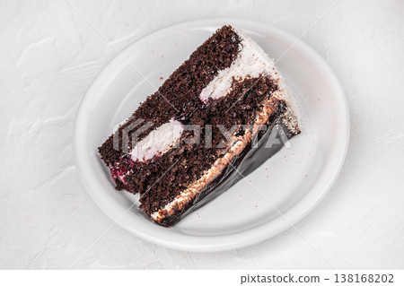 Chocolate cake slice on white plate top view on light background Chocolate cake slice on white plate top view on light background 138168202