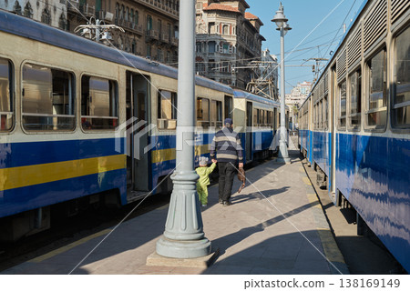 一位家長帶著孩子走在亞歷山大拉穆爾車站的電車之間。 138169149