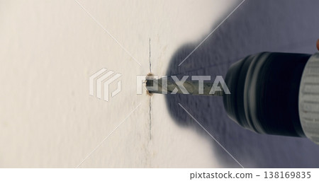 Drilling a hole in a wall using a power drill for home improvement tasks on a weekend afternoon 138169835