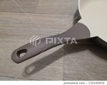 Close up of a modern frying pan handle with a minimalist design on a neutral textured background 138169958