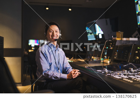 A director working in a broadcasting station's control room A director working in a broadcasting station's control room 138170625