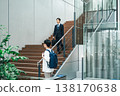 Businessman walking up the stairs of an office building 138170638