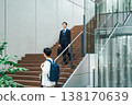 Businessman walking up the stairs of an office building 138170639