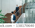 Businessman walking up the stairs of an office building 138170640