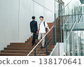 Young man walking up the stairs of an office building 138170641