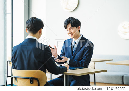 A young businessman giving an explanation in a free space. A young businessman giving an explanation in a free space. 138170651