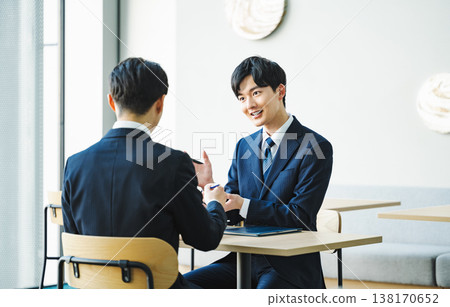 一位年輕的商人，在商務談判中使用手勢和肢體語言。 138170652